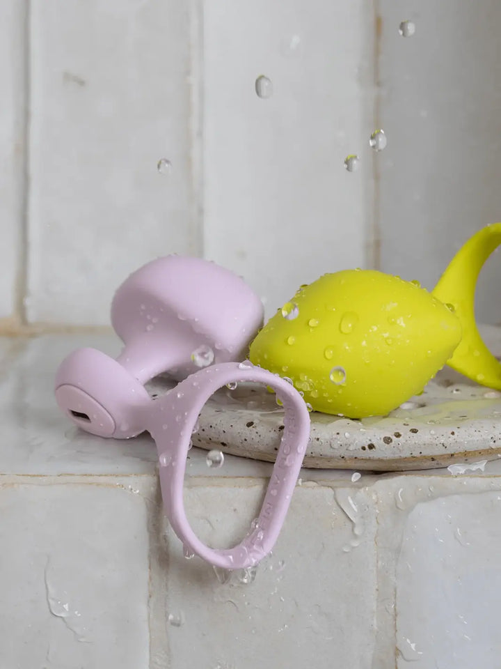 Dame Fin 2.0 Finger Vibrators in Quartz and Citrus shown in a waterproof lifestyle setting.