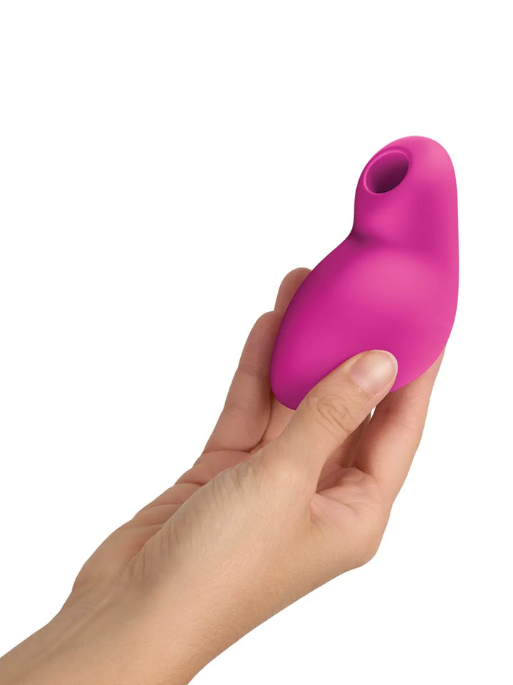 FUN FACTORY Allure in pink shown in hand with compact curved silicone body.