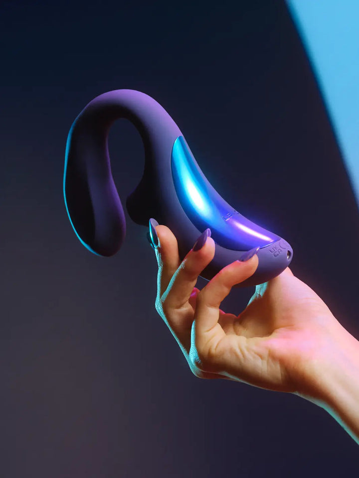 LELO Enigma Wave in cyber purple lifestyle image shown in hand with illuminated accent detail.