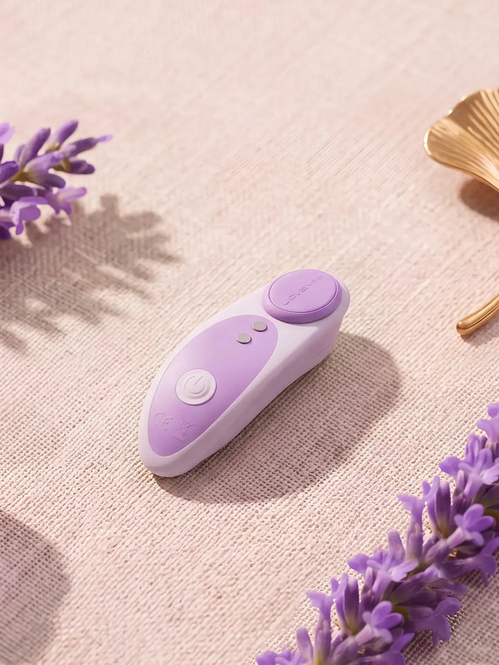 Lovense Ferri Reserve purple vibrator styled on soft fabric with flowers