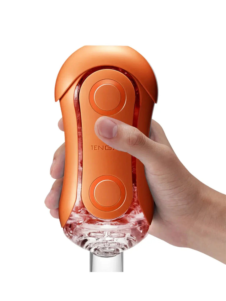TENGA Flip Orb Sunset Orange shown in hand with compact shape and easy-grip pressure pads.