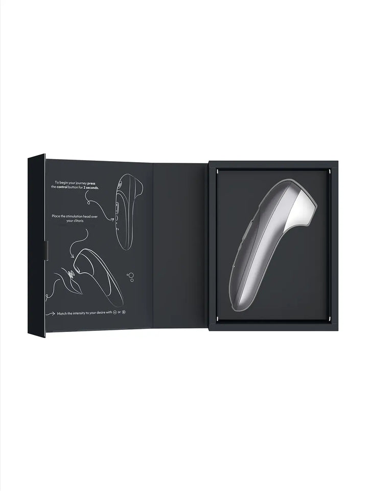 Womanizer Pro silver shown with open box packaging and product insert.